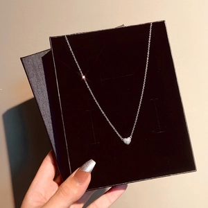 Detail of silver heart pendant necklace with full diamond pave in a black velvet jewelry box