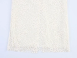 Nahaufnahme von elegantem, cremeweißem Spitzenstoff mit feinen floralen Mustern und Details