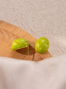 Close-up of green marble texture stud earrings with golden metal base on silk
