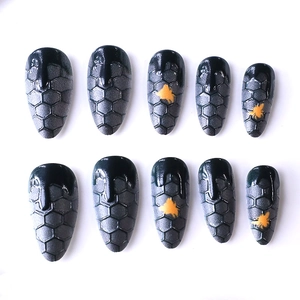 Long almond press-on nails with 3D honeycomb texture and black drip design in 10 pieces