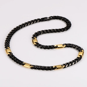Detailed close-up of a two-tone black and gold chunky Cuban link chain necklace