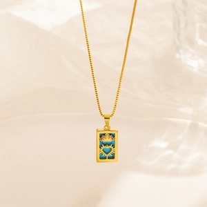 Detail of vintage gold necklace featuring rectangular blue pendant with crown and heart motifs