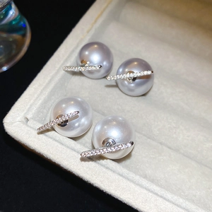 Macro shot of silver pearl studs with pavé zircon bar in grey and white tones