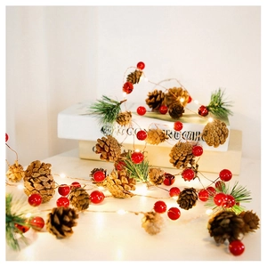 Close-up of LED fairy lights with pine cones, red berries and warm glowing needles
