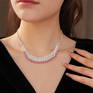 Detailed view of silver multi-layered rhinestone necklace with pink pear-cut tassels