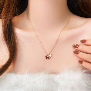 Close-up of gold-plated necklace with red enamel puppy and zircon heart on model neck