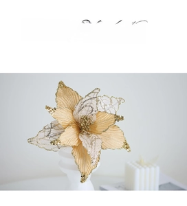 Detailed view of artificial Christmas poinsettia flower with golden sequins on white base