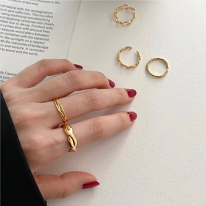 Close-up of set of five gold twisted and braided stackable rings on a model hand