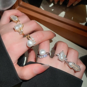 Detailed macro view of Baroque irregular pearl rings with zircon accents on gold and silver bands