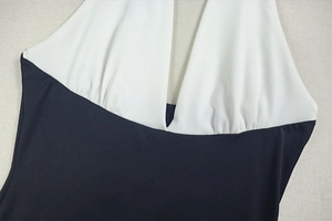 Detail of the plunging V-neckline with white accordion pleats on black dress