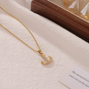 Collier élégant avec pendentif ancre dorée et strass brillants sur une chaîne fine