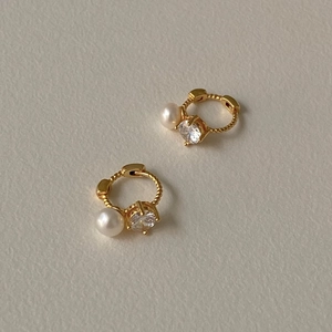 Elegant gold earrings with round white pearls and sparkling zircon stones in a huggie style