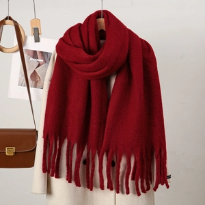 Détail d'une écharpe épaisse bordeaux style cachemire avec des franges et texture
