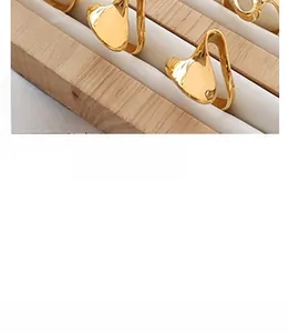 Macro detail of irregular wave 18K gold plated titanium steel earrings on display
