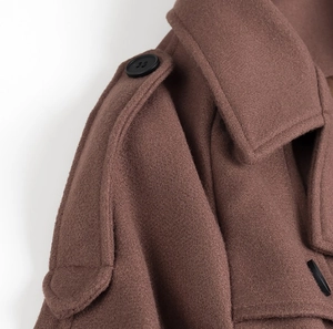 Détail du manteau en laine marron avec épaulettes et coutures sur le revers