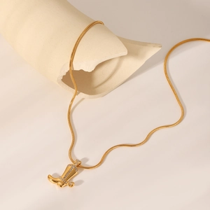 Vue détaillée d'un pendentif botte de cowboy doré serti de diamants sur chaîne serpent