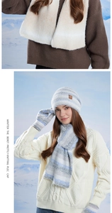 Dettaglio del set invernale in maglia sfumata bianca e blu con sciarpa e guanti sulla neve