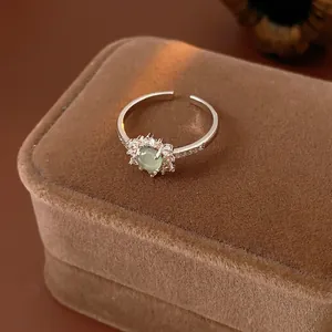 Vintage adjustable silver ring with green sunflower zircon on a brown velvet box