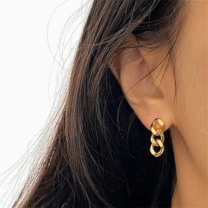 Golden stainless steel Cuban chain earrings shown on model in a minimalist style