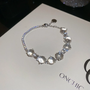 Vue macro d'un bracelet en argent avec cristaux ronds sur une carte de présentation