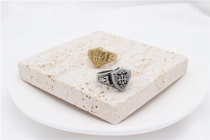 Detailed close-up of retro silver and gold shield rings with cross engravings on stone