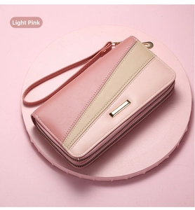 Macro detail of multi-tone long leather wallet with gold metal trim and zipper