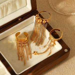Close-up of golden tassel rings and pearl star charms on a luxury jewelry box lining