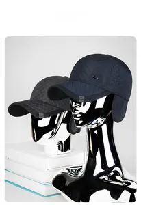 Detail of winter baseball hat with quilted fabric, ear flaps and metallic buckle