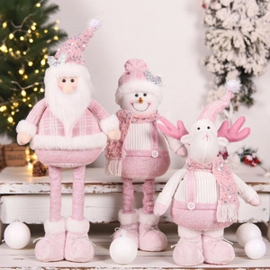 Pink Christmas plush figurines set with Santa, snowman and reindeer on white wood