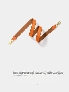 Detail of orange and brown woven bag strap with leather ends and gold spring clasps