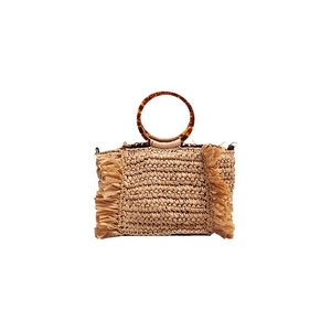 Handwoven straw beach bag with tortoiseshell ring handles and tassel details