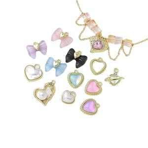 DIY jewelry charms with heart and bow designs featuring pearls and zircon crystals