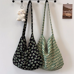 Floral canvas tote bags with green heart patterns in black and cream styles