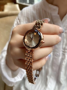 Close-up of rose gold watch with rhinestone markers and solid steel chain band