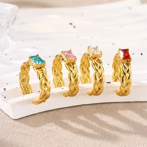Close-up of gold braided C-shape rings with colorful rectangular zircon gemstones