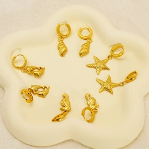 Detail of 18K gold plated hoop earrings with sea star, seahorse, and shell charms