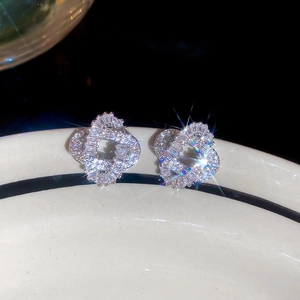 Detailed view of silver heart intertwined earrings with sparkling zircon inlay