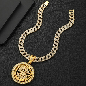 Detail of rotating gold dollar sign pendant with white rhinestones and cuban link chain