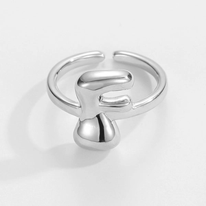 Detailaufnahme eines silbernen, verstellbaren Rings mit markantem 3D-Buchstaben F Design