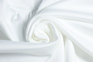 Vue macro du tissu blanc pur de la robe montrant le tissage synthétique et son éclat