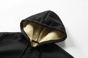 Detail der schwarzen Kapuzenjacke mit warmem cremefarbenem Fleece-Futter und Reißverschluss