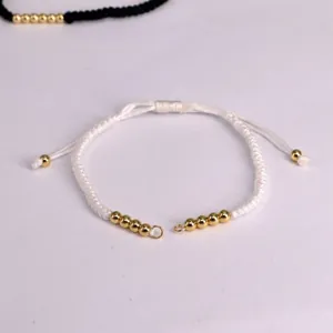 Adjustable white braided Milan cord bracelet with gold metal beads and sliding clasp