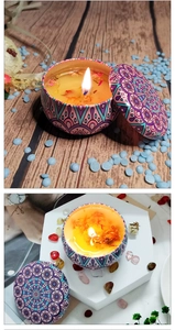 Detailed top view of scented soy candles with dried flowers in mandala tin cans