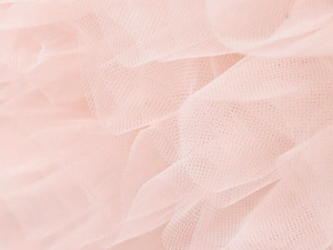 Detail-Makroaufnahme aus weichem rosa Tüll mit leichter Netzstruktur und luftigen Lagen