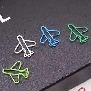Macro shot of creative airplane shaped metal paperclips in white, blue and green colors