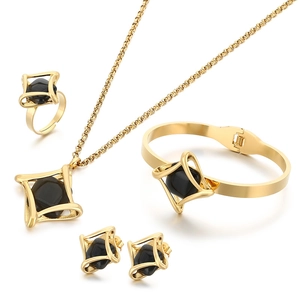 Luxurious gold stainless steel jewelry set with geometric black stones on white background