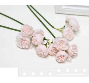 Detail showing artificial pink tea rose branches with lifelike petals on white background
