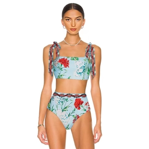 Dettaglio dello slip bikini a vita alta con stampa floreale e bordo in pizzo nero a onde