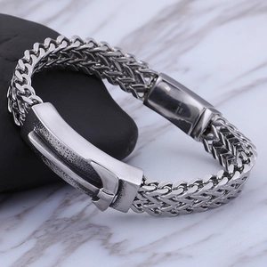 Macro detail of 316L stainless steel engraving on silver cuban chain mens bracelet