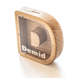 Macro shot of D-shaped oak wood money box with transparent acrylic panel and custom name
